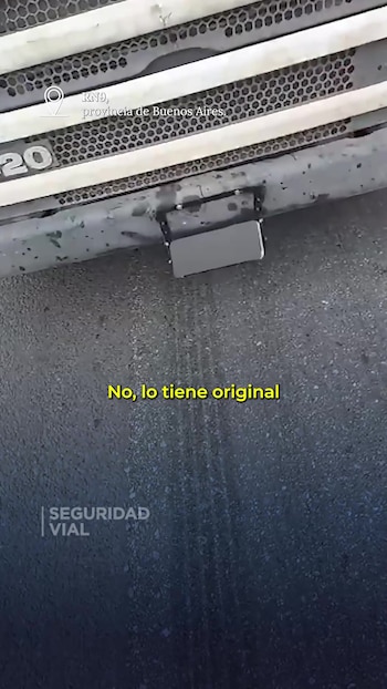 Paragolpes delantero de un camión con un dispositivo metálico sobre la chapa patente en una carretera