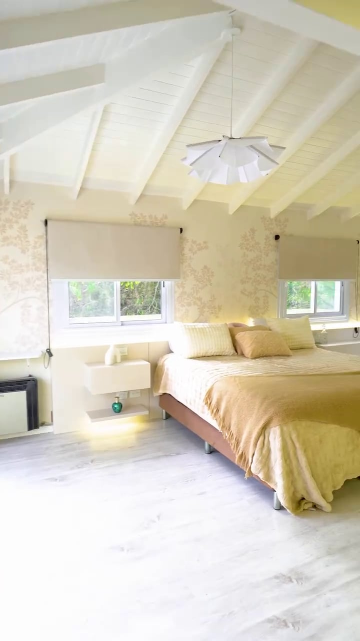 La nueva habitación de Moria Casán presenta una cama matrimonial, paredes empapeladas y un techo de madera blanca tras su remodelación.