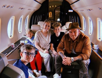 Un hombre con sombrero, una mujer y tres niños permanecen sentados en los sillones de un avión ejecutivo