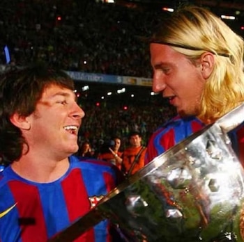 Lionel Messi y Maxi López con la camiseta del Barcelona sostienen un trofeo metálico en un estadio