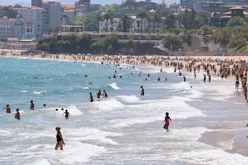 Cientos de bañistas, vecinos y visitantes se refugian del calor en la playa de El Sardinero de San Sebastián, a 26 de junio de 2026. (EFE/Celia Agüero Pereda)