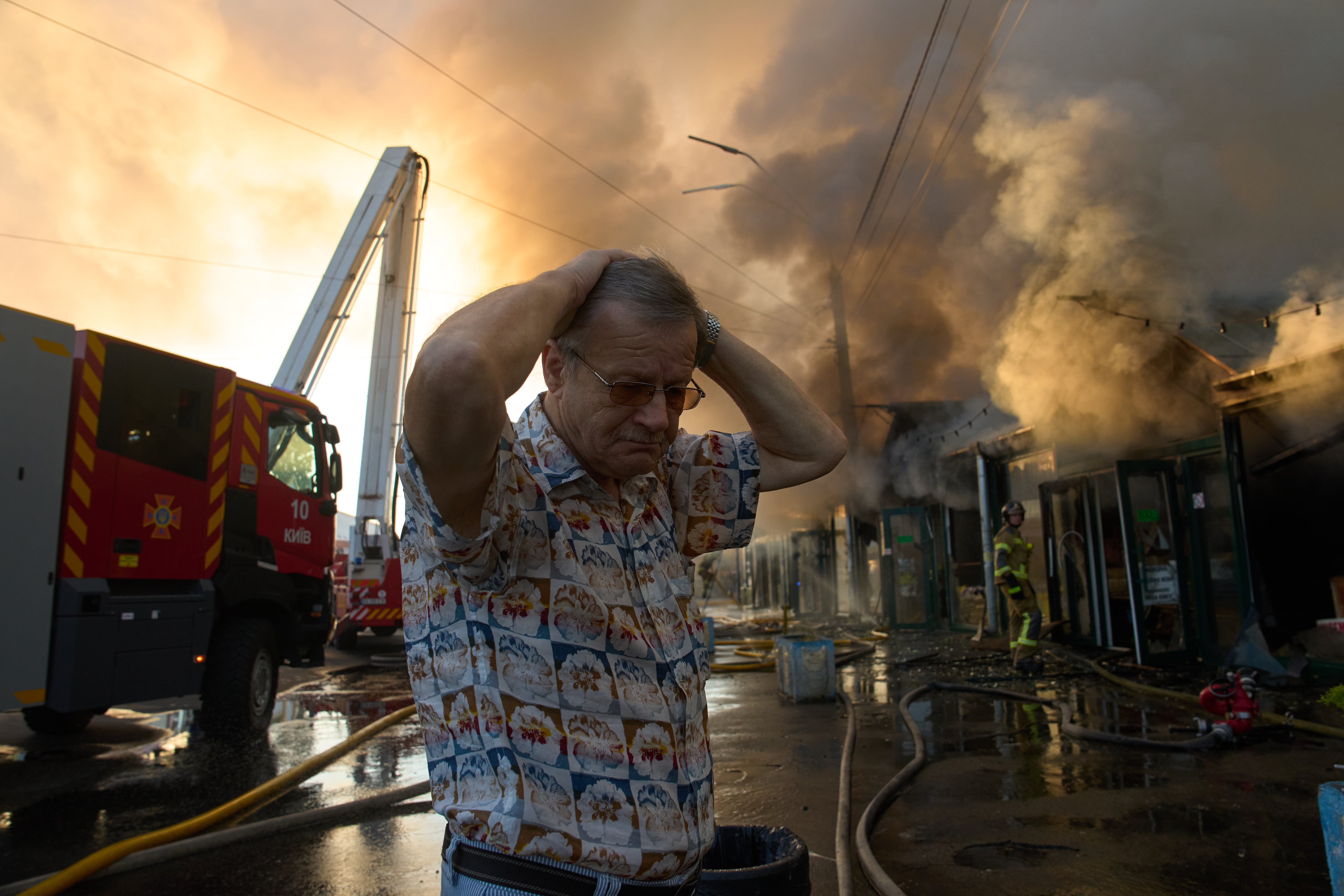El librero Alexander Bahlai reacciona mientras los bomberos intentan sofocar un incendio en un mercado de libros de la ciudad tras un ataque con misiles rusos en Kiev, Ucrania, el 16 de agosto de 2026. (Foto AP/Francisco Seco)