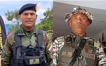 Dos hombres con uniforme militar. Uno viste boina negra, chaleco táctico negro y lleva bandera de Venezuela. Otro usa sombrero de camuflaje y chaleco táctico