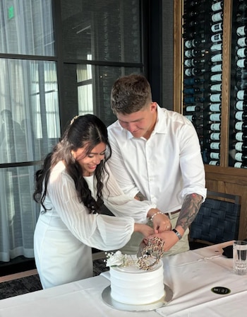 Matthew Blank y su esposa, Annie Ramos, cortando un pastel durante la celebración de su boda en marzo de 2026, en Houston (Foto cortesía CBS).