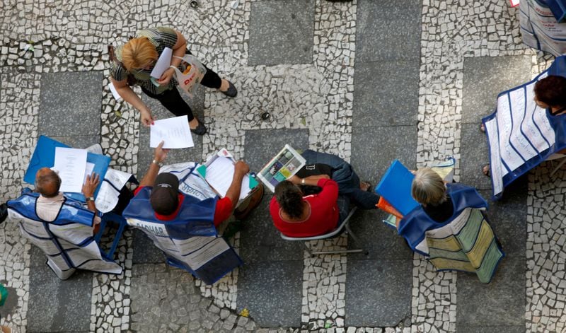 Un grupo de personas repartiendo volantes con puestos de trabajo en una calle en San Pablo (REUTERS/Paulo Whitaker/Archivo)