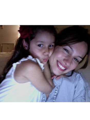 Pampita sonríe mientras su hija Blanca, con un vestido blanco y una flor roja en el pelo, le da un abrazo y hace pucheros a cámara