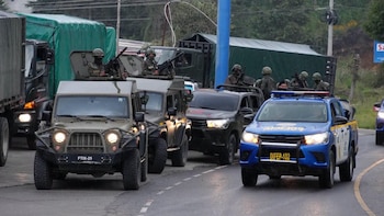 Fila de soldados en uniforme de camuflaje y boinas oscuras que sostienen sus armas
