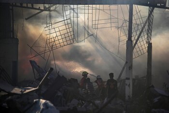 Palestinos inspeccionan los escombros de un edificio destruido tras un ataque aéreo israelí en el barrio de Al-Zawaida (EFE/EPA/MOHAMMED SABRE)