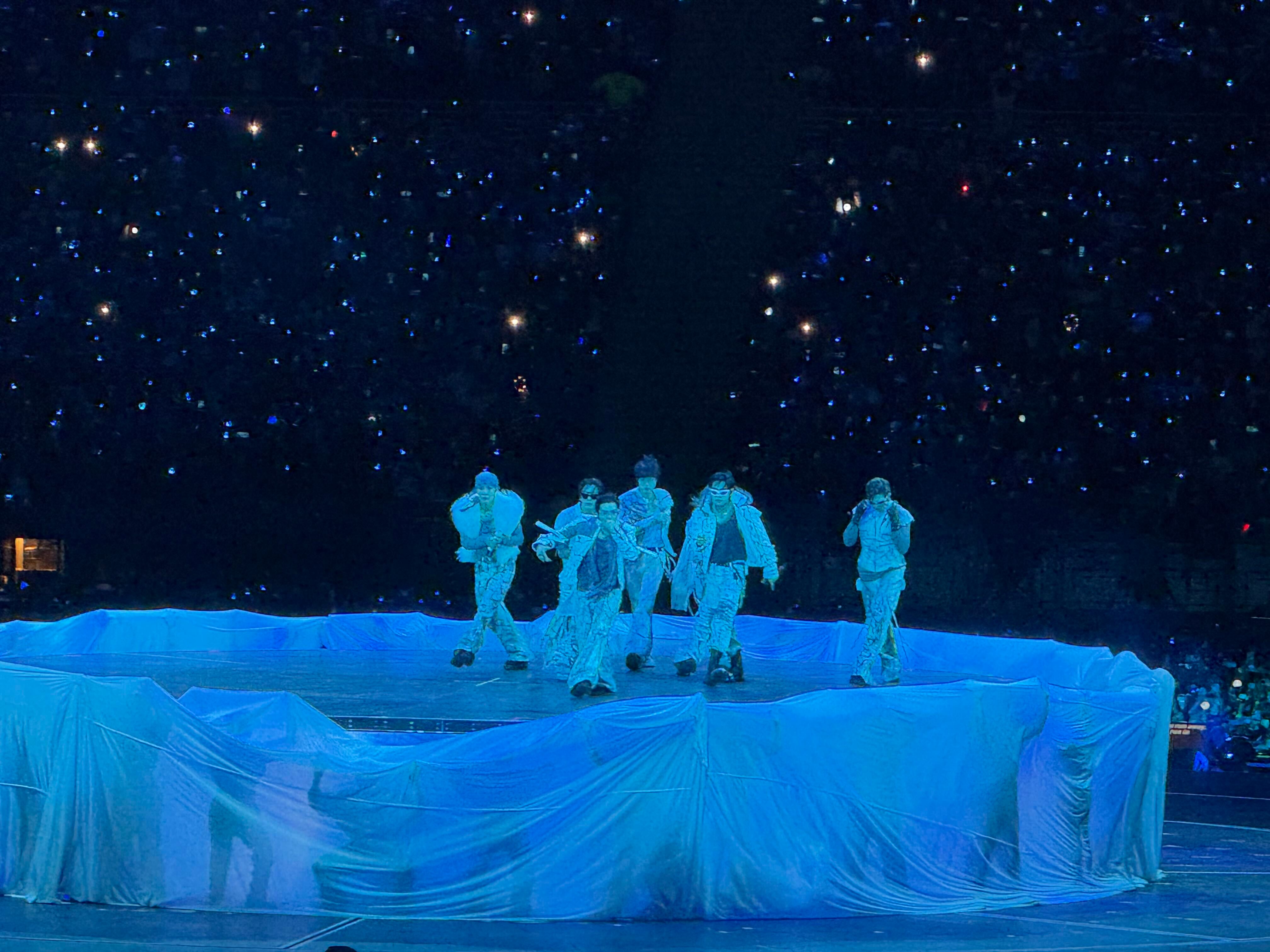 Los integrantes del grupo surcoreano BTS realizan una presentación sobre un escenario iluminado durante su concierto en el Estadio San Marcos de Lima. (Paula Diaz)