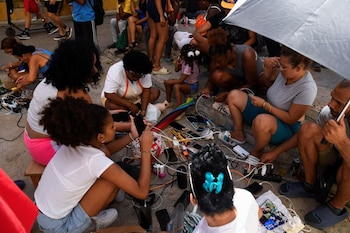 Varias personas cargan sus teléfonos móviles durante el colapso de la red eléctrica nacional, en La Habana, Cuba. 15 de marzo de 2025. REUTERS/Norlys Perez