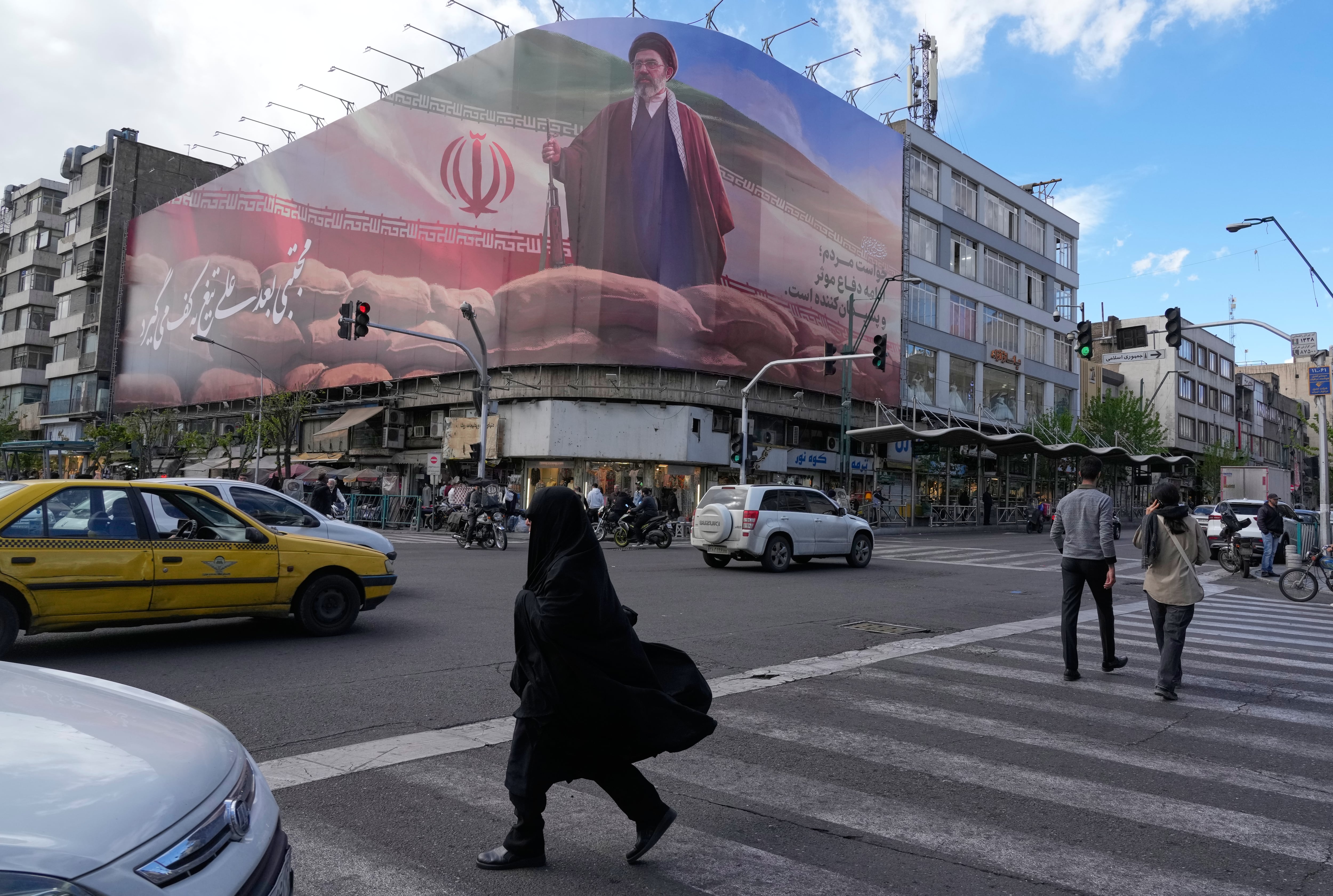 Transeúntes en Teherán junto a una imagen de Mojtaba Khamenei el 6 de abril. (Foto AP/Vahid Salemi)