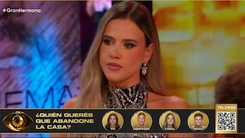 Mujer en primer plano con blusa brillante y aros, fondo difuso. Banner con texto "#GranHermano", "TELINFOR", código QR y nombres de participantes