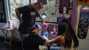 Dilan realizando un tatuaje mientra