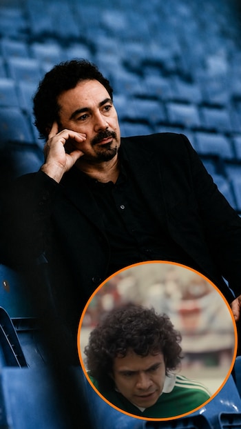 Hombre con traje negro y barba sentado en gradas azules, pensativo. Un círculo superpuesto muestra a un joven de cabello rizado con camiseta verde de fútbol, expresión seria