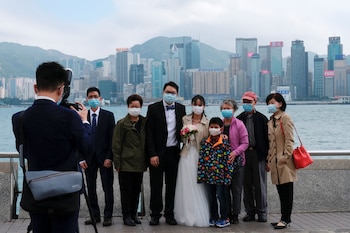 Una pareja de recién casados y su familia se toma una foto con el distrito financiero de Hong Kong de fondo. Foto: REUTERS/Tyrone Siu