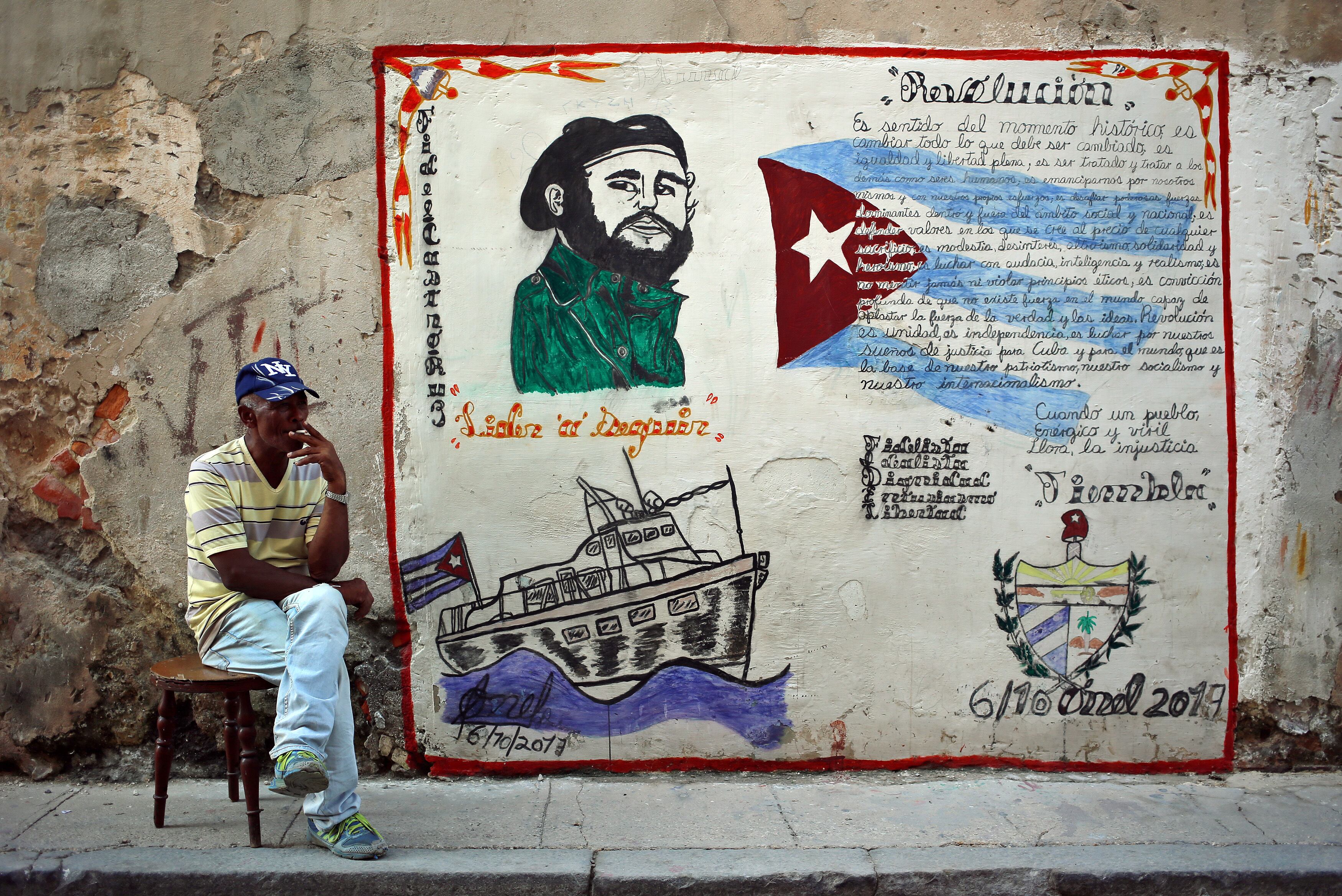 Fotografía de archivo en la que se registró a un hombre junto a un muro con la imagen de Fidel Castro, en La Habana (EFE/Alejandro Ernesto)