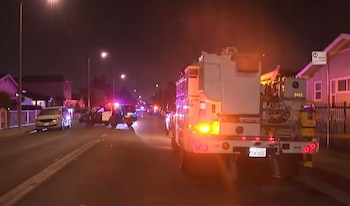 Vehículos de emergencia y patrullas de policía con luces encendidas estacionados de noche en una calle residencial