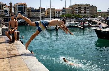 Un joven se lanza al agua este lunes en el puerto de San Sebastián, a 22 de junio de 2026. (EFE/ Javier Etxezarreta)