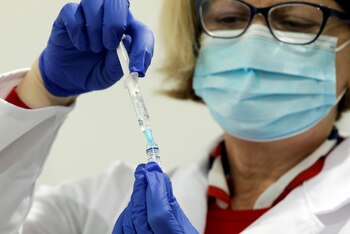 Una enfermera prepara una dosis