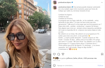 Primer plano de una mujer de cabello rubio, gafas de sol y collar dorado en una calle urbana con edificios y coches al fondo