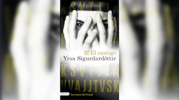 Portada del libro "El Castigo" de Yrsa Sigurðardóttir, con un rostro cubierto por manos del que asoma un ojo, en tonos blanco, negro y dorado