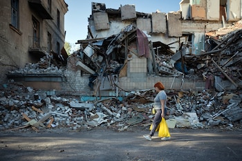 FILE — A woman walks past the wreckage of destroyed buildings in Sloviansk, in the Donbas region of Ukraine, on Sept. 14, 2025. Moscow says its capture of the region is inevitable. But Kyiv has so far stymied Russian efforts to encircle Ukrainian “fortress belt” cities. (Tyler Hicks/The New York Times)