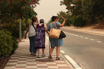Varias personas atienden a las órdenes de evacuación durante el incendio forestal, a 25 de julio de 2026, en Cadalso de los Vidrios, Madrid (España). (Eduardo Parra/Europa Press)