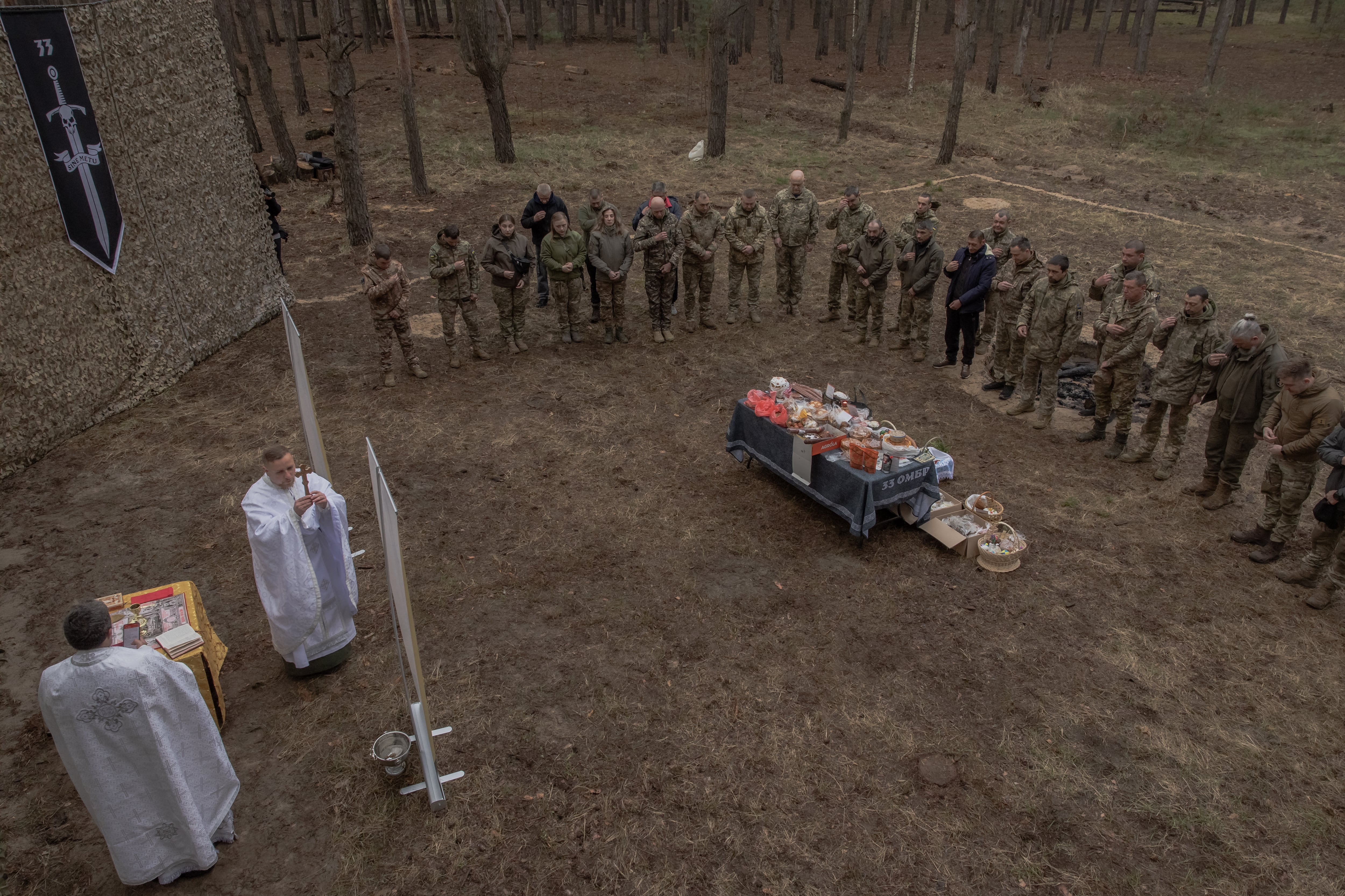Capellanes oran junto a militares de la 33ª brigada mecanizada durante las celebraciones de Pascua ortodoxa en la región de Járkov. Ucrania lleva más de cuatro años en guerra, el conflicto más sangriento en Europa desde la Segunda Guerra Mundial. (Roman PILIPEY / AFP)