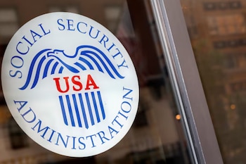 Un logotipo circular de la Administración del Seguro Social con un águila azul y la palabra "USA" en rojo se ve en un cristal
