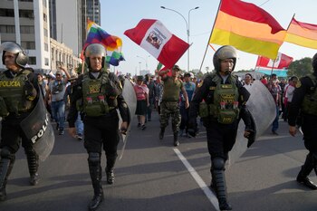 Policía antimotines camina delante de