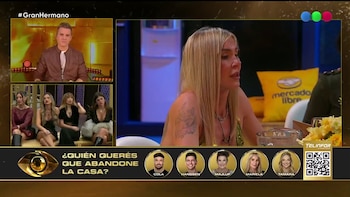Pantalla dividida con un presentador, cuatro mujeres sentadas, una mujer rubia sentada y un banner inferior con pregunta de votación y seis perfiles de concursantes