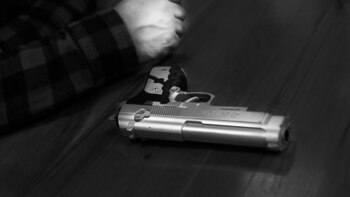 Während er mit einer Waffe