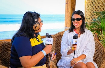 Adriana Larín, directora de la Autoridad del Centro Histórico, durante una entrevista en YSKL desde la playa El Tunco, en el marco del ISA World Junior Surfing Championship 2026 (Cortesía: Secretaría de Prensa).