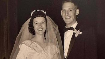 Retrato en blanco y negro de una pareja el día de su boda; la novia lleva un vestido con velo y tiara, y el novio un esmoquin con pajarita