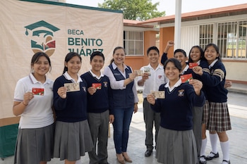 Un grupo de estudiantes mexicanos sonrientes de secundaria y preparatoria, junto a una mujer, muestran tarjetas bancarias y billetes frente a una lona de Beca Benito Juárez.