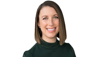 Retrato de mujer sonriente con cabello castaño hasta los hombros, ojos azules y top verde oscuro, mirando a cámara sobre fondo blanco