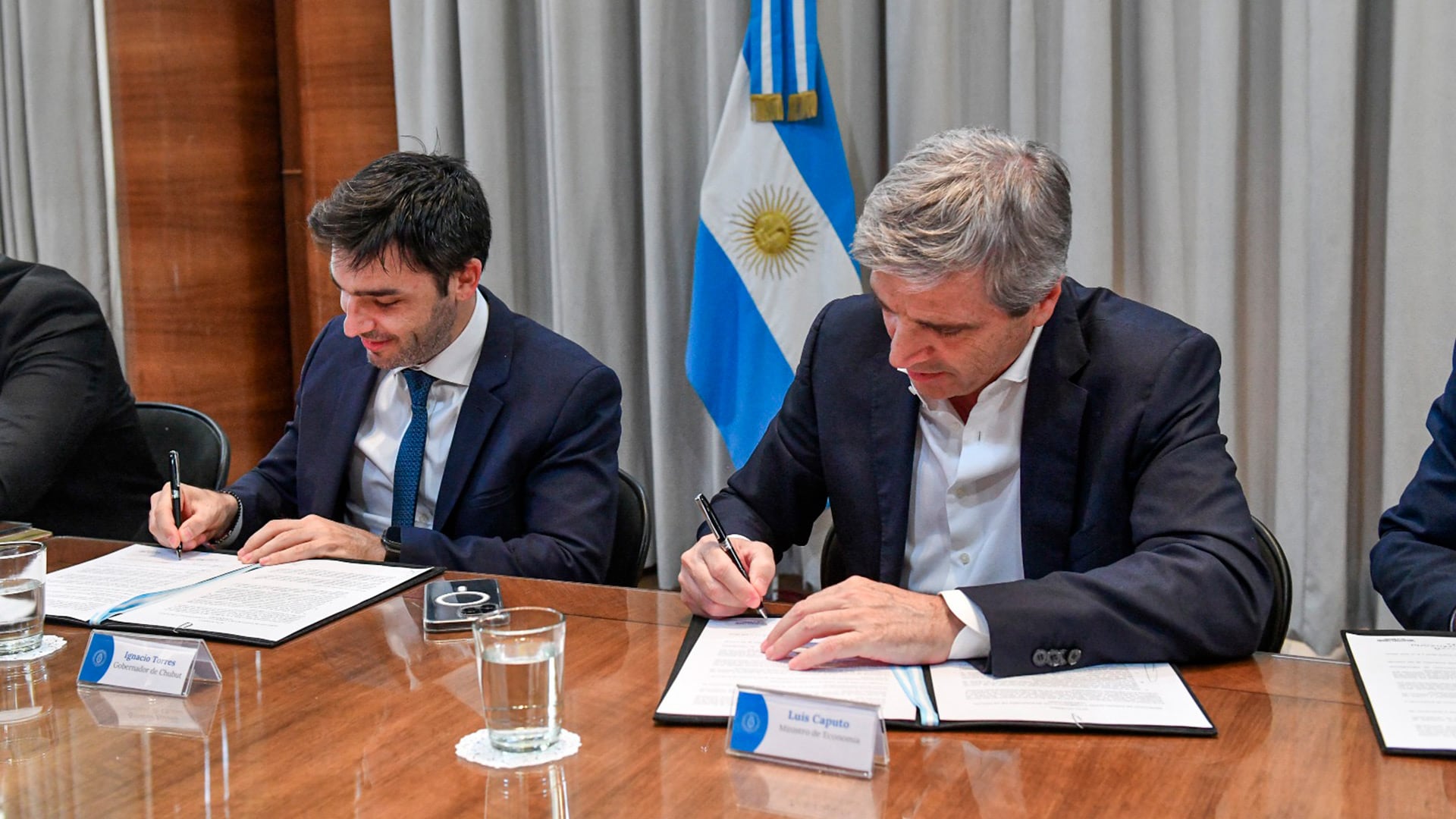 El ministro de Economía, Luis Caputo, y el gobernador de Chubut, Ignacio Torres, firmando la reducción de retenciones