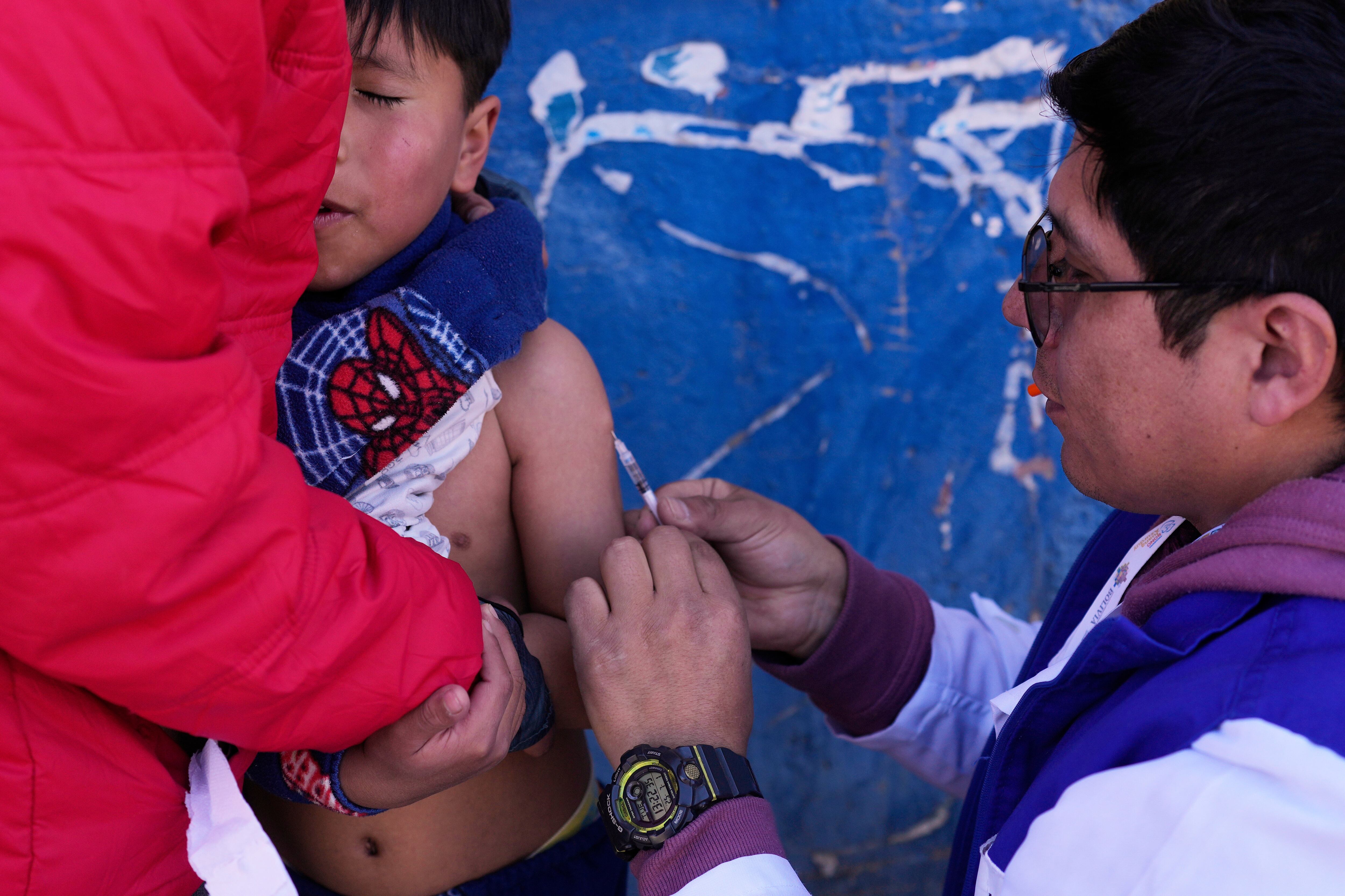 Un trabajador de salud pone una vacuna a un niño en una campaña puerta a puerta contra el sarampión en La Paz, Bolivia, el martes 1 de julio de 2025. (AP Foto/Juan Karita)