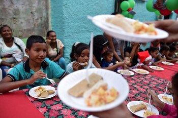 Niños comen "Hallacas", un plato