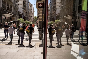 Peatones con máscaras protectoras caminan