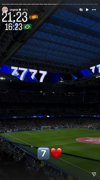 Vista aérea de un estadio de fútbol por la noche con campo iluminado, tribunas llenas y pantallas gigantes. Se observa el número 7 y un corazón en primer plano