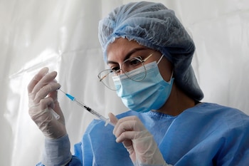 Una enfermera prepara una dosis