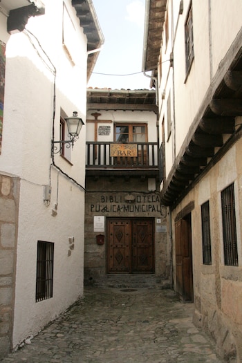 Se aprecia un callejón en el que al final hay una biblioteca y un bar en la segunda planta.