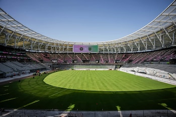Estadio moderno con césped verde, gradas vacías rosa y gris, y marcador digital mostrando 'MIAMI vs AUSTIN'. Cielo azul claro