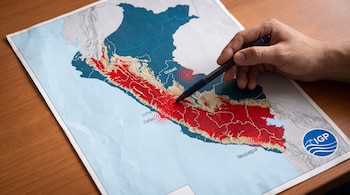 Mapa impreso de Perú sobre una mesa, con círculos rojos de epicentros, el logotipo del IGP y una mano que señala una región con un bolígrafo.