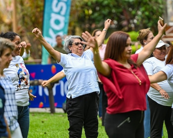 Participantes disfrutan la dinámica “Madres en Movimiento”, conducida por Balmore Ticas de la Federación Salvadoreña de Baile Deportivo, durante una jornada que promovió el bienestar y la integración mediante ejercicios de estiramiento. (Cortesía: Comité Olímpico de El Salvador)