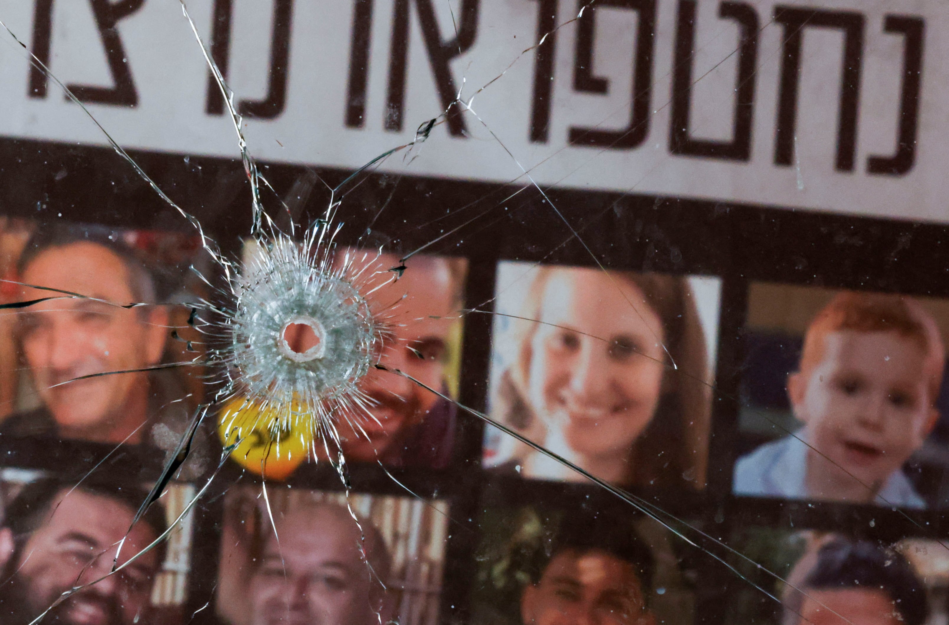 ARCHIVO: Un agujero de bala en un cristal roto frente a imágenes de rehenes, tras el mortífero ataque de Hamás del 7 de octubre de 2023, en el kibutz Nir Oz, Israel, el 19 de febrero de 2025 (Reuters)
