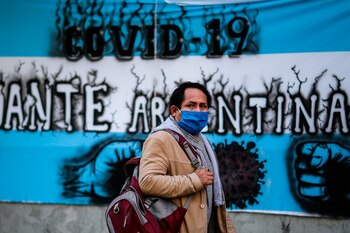 Una persona con tapabocas camina