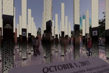 Columnas verticales iluminadas con nombres y retratos grabados junto a una piedra con la inscripción de la fecha 1 de octubre de 2017