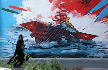 Una mujer pasa delante de un mural en Teherán que hace referencia a los ataques de Irán contra la Armada de Estados Unidos (EFE/EPA/ABEDIN TAHERKENAREH)
